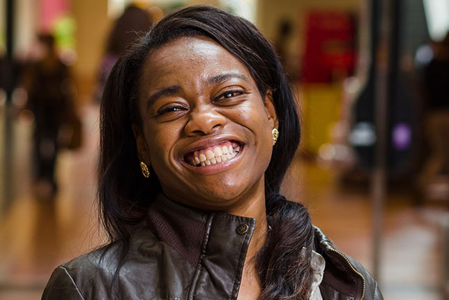 Beautiful smiing young woman who is learning to use a white cane at the mall - image