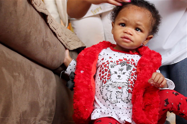 Young toddler learning to walk in her living room image.