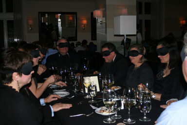 Dining in the Dark participants, blindfolded at the dinner table