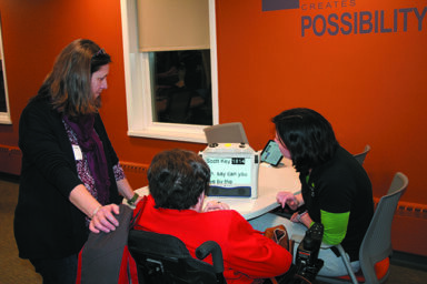 Jacci Borchardt, Program Director, demonstrates the Eye-Pal Ace Plus, a portable magnifying device that converts text to speech. Img