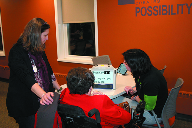 Jacci Borchardt, Program Director, demonstrates the Eye-Pal Ace Plus, a portable magnifying device that converts text to speech. Img