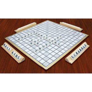 Deluxe low vision scrabble on a table. Scrabble tiles are arrnged to spell "Scrabble' and 'Maxi Aids'