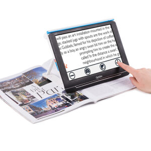 The Compact 10 sits on top of a magazine. A woman's hand is seen reching out to touch the screen.