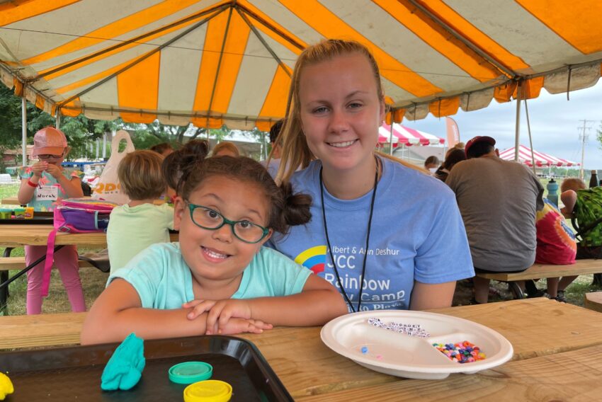 Photo of young girl and volunteer at camp.