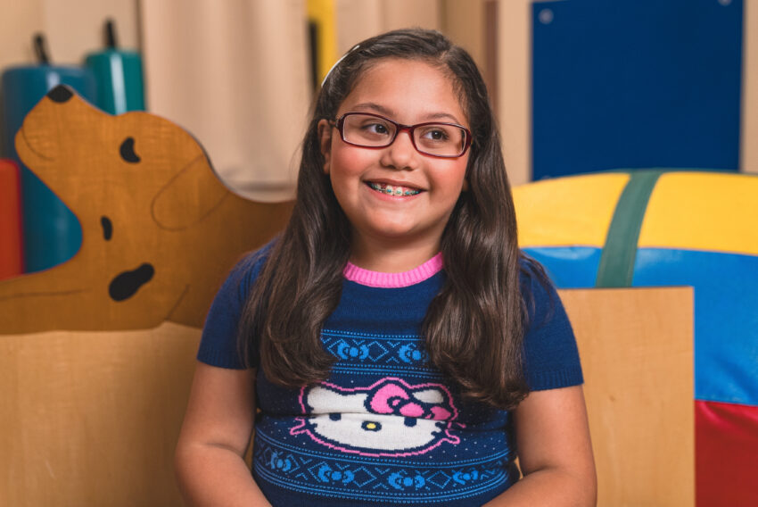 Girl with dark hair and glasses with hello kitty shirt on