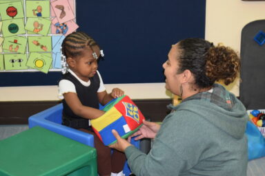 preschool visually impaired child with teacher playing with toy