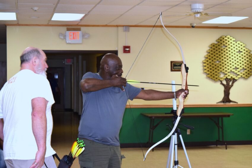 man with visual impairment learning archery