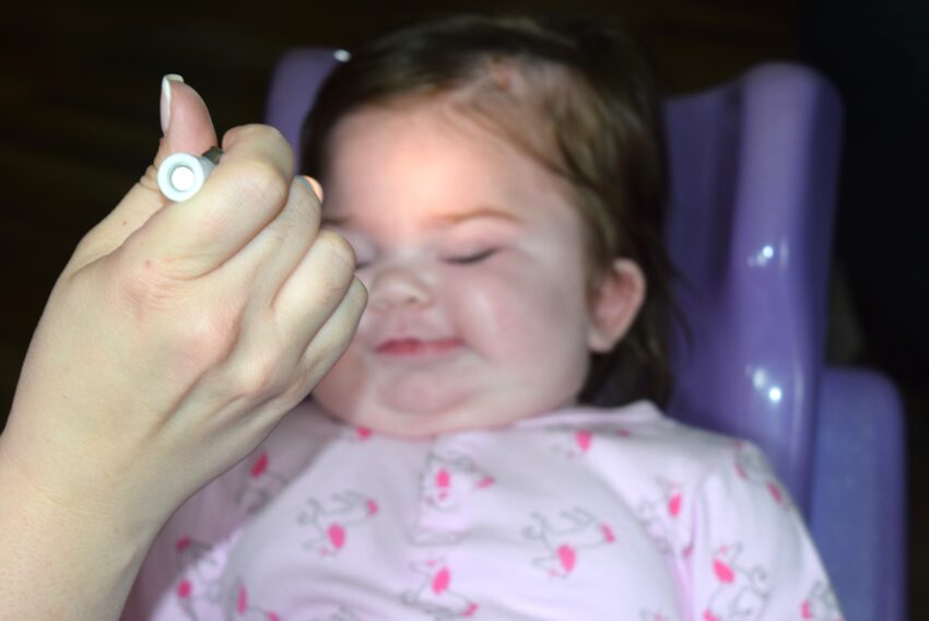 baby girl being tested with light to determine visual impairment