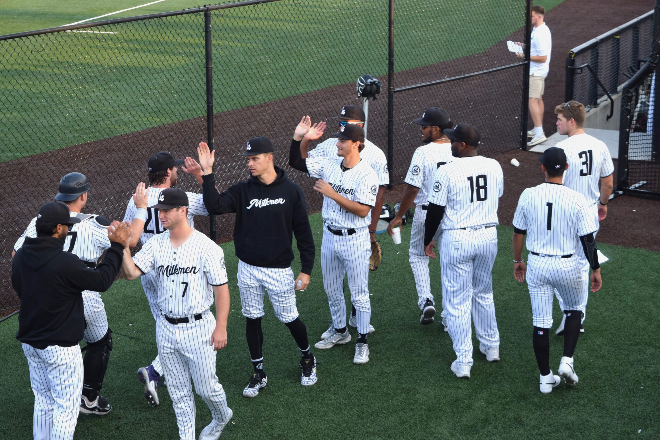 milwaukee milkmen players giving high fives in dugout