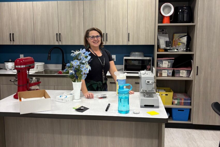 Woman standing behind kitchen counter with appliances