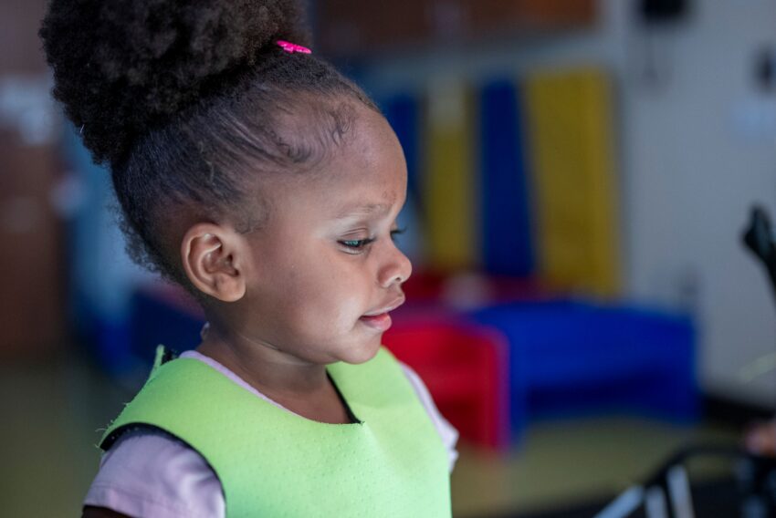 little girl profile with her face lighted. She is looking and concentrating on something below the photo frame