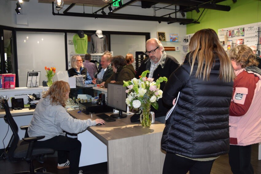 Crowd of people in the vision forward store buying items and looking at them.