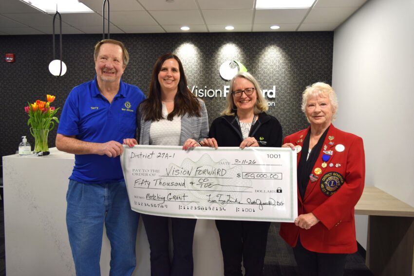 Four people holding a check for Vision forward for 50,000.